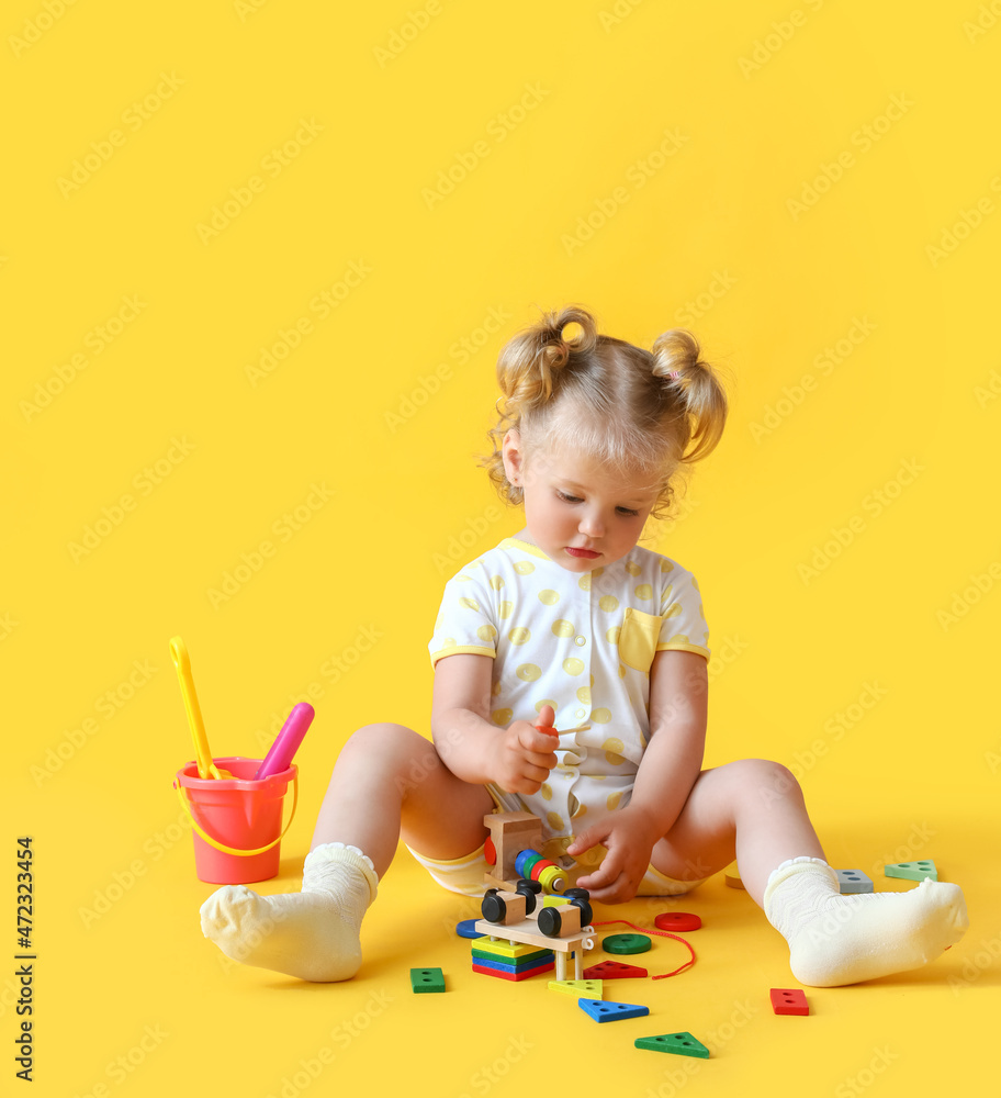 可爱的女婴，彩色背景上有玩具