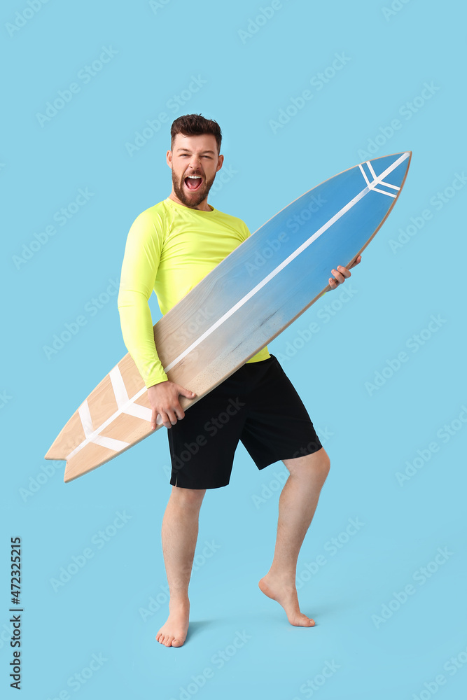 情绪化的年轻胡须男子，蓝色背景上有冲浪板