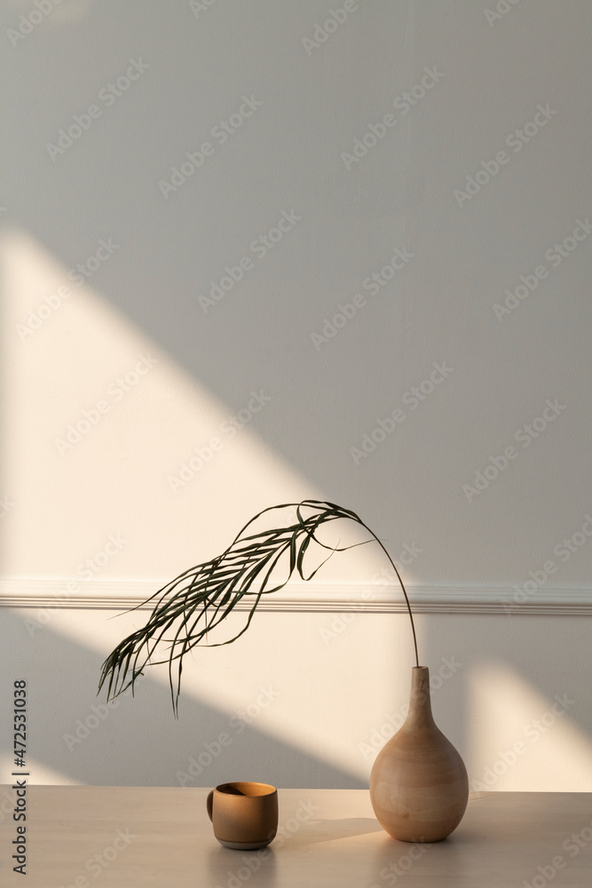 在一个有自然光的白色房间里放一个最小的木制花瓶