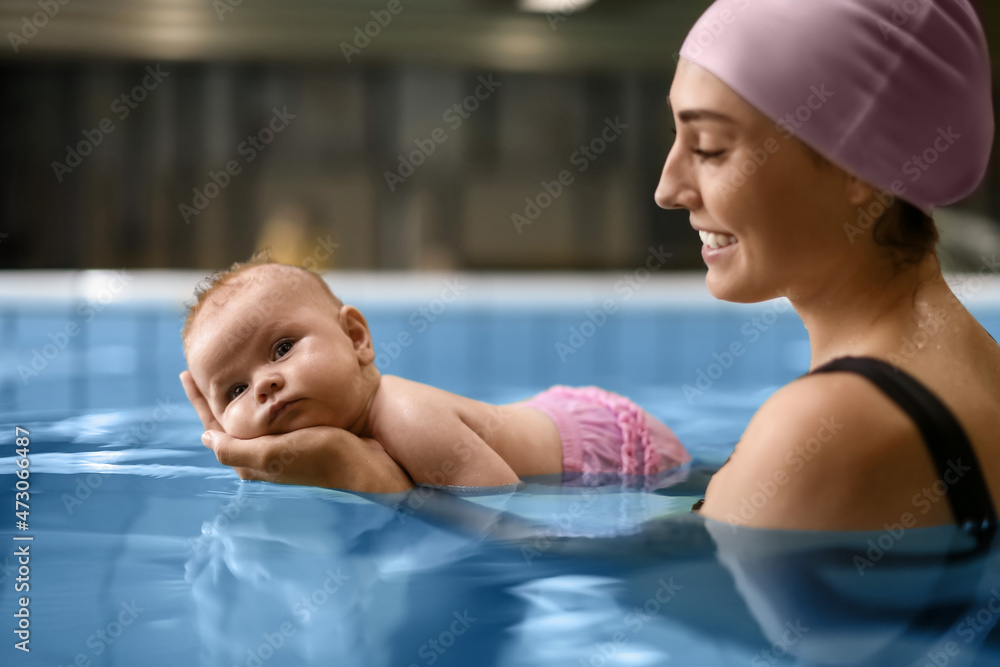 可爱的宝宝和妈妈在游泳池