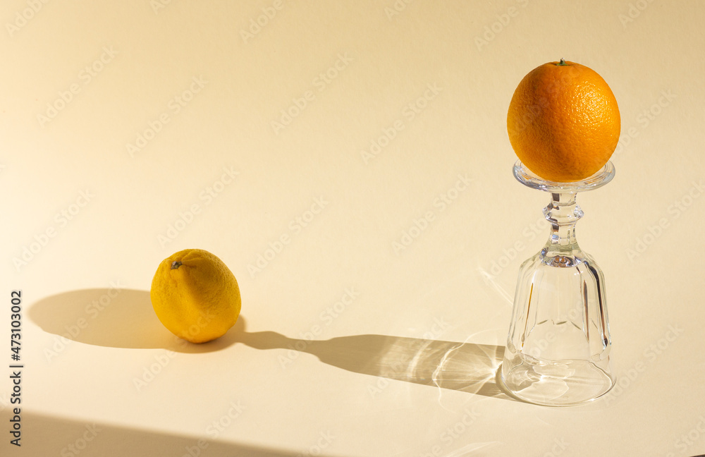 倒置的空高脚杯阴影；橙色、水晶玻璃和水果在柔和的贝格上的强光下