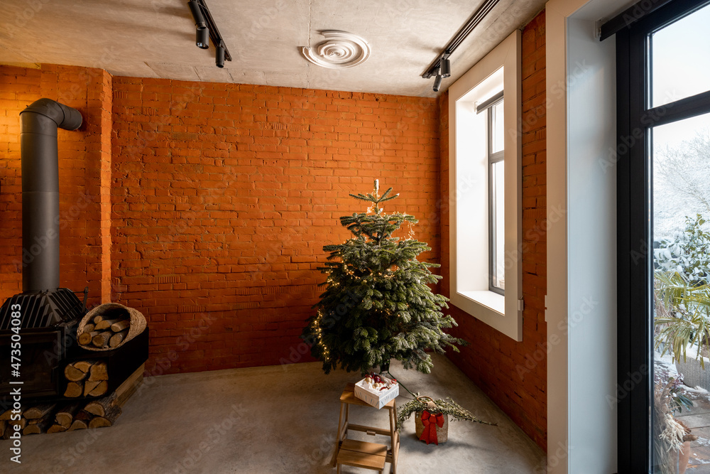 舒适的客厅内部，角落里有圣诞树。冬季居家舒适的概念。风