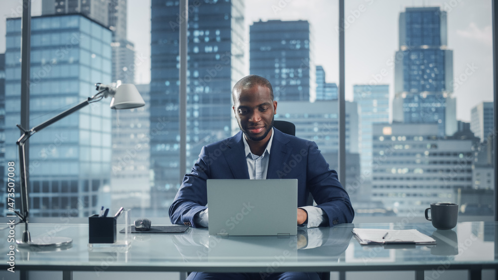 成功黑人商人在大城市办公室用笔记本电脑工作的肖像。教授