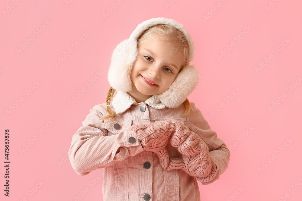 穿着时尚冬装的小女孩，双手放在彩色背景上，露出心形