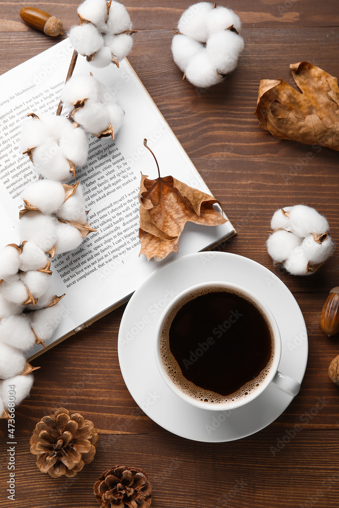 一杯咖啡，打开的书，棉花花和木制背景的秋季装饰
