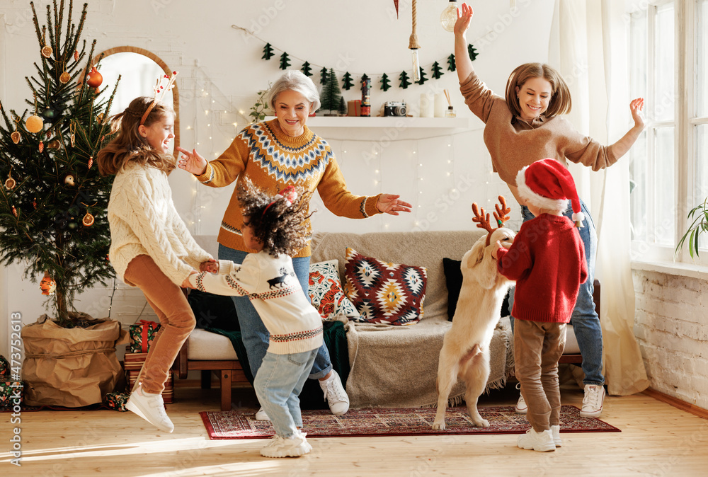 快乐的多种族家庭，有三个孩子和金毛寻回犬，圣诞节在家玩得很开心