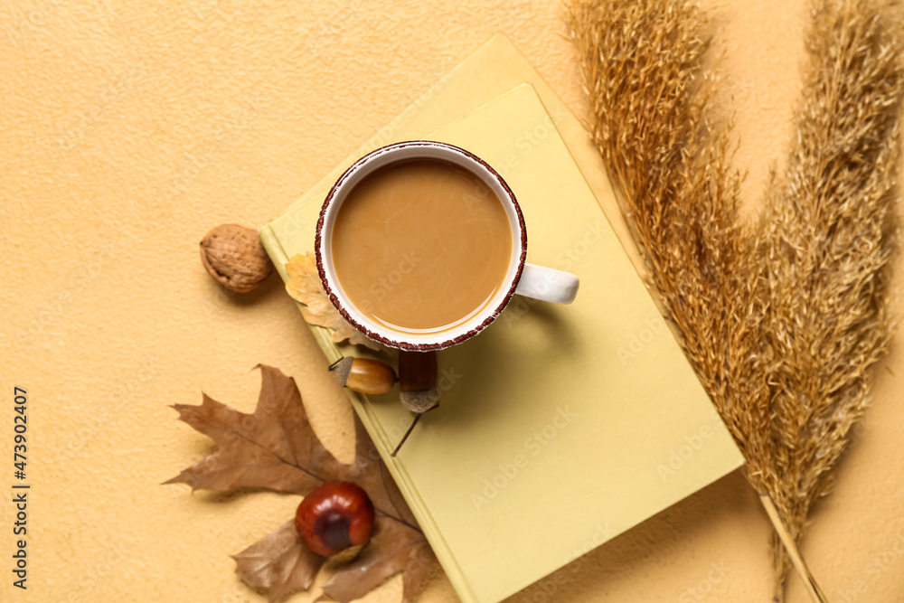 一杯美味的咖啡，米色背景的书籍和秋季装饰