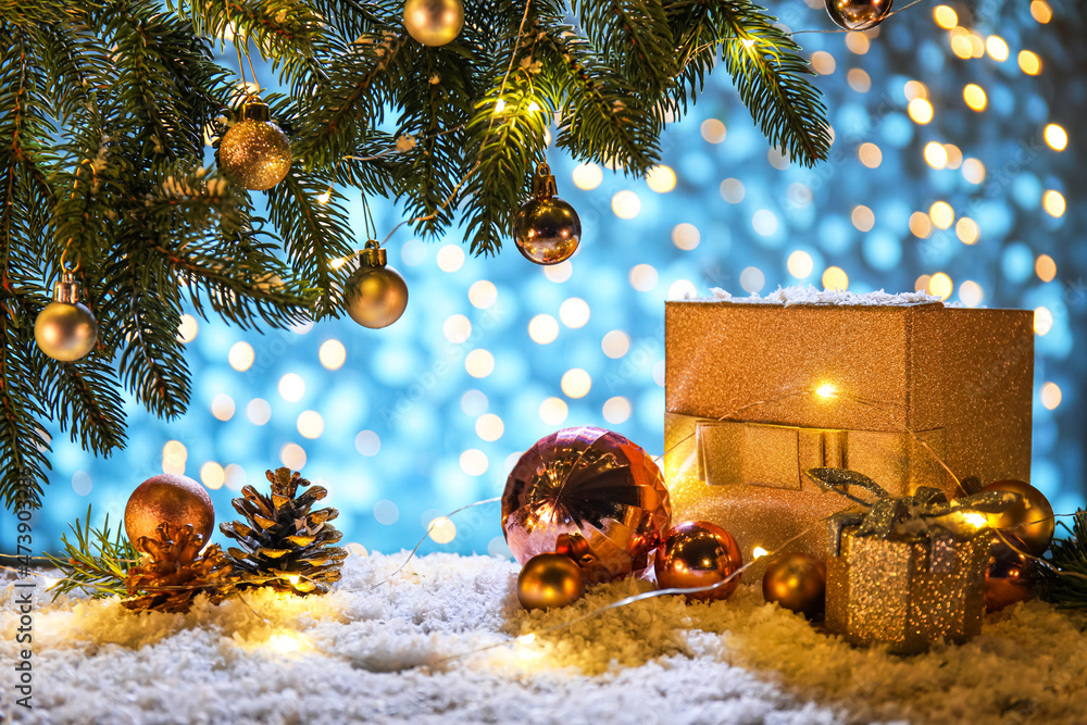 美丽的圣诞构图，有冷杉树枝、礼品盒和雪地上发光的灯光