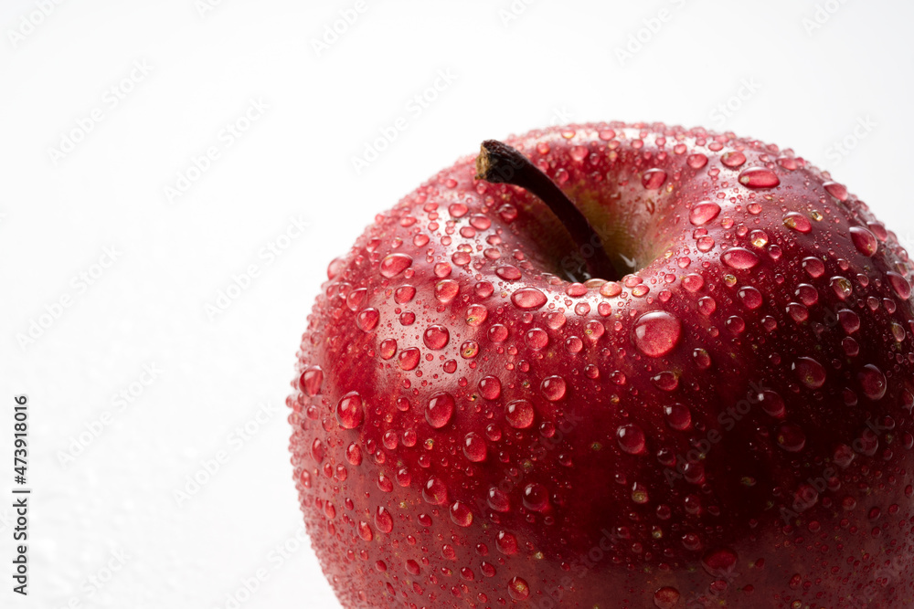 白色背景上有水滴的苹果特写。