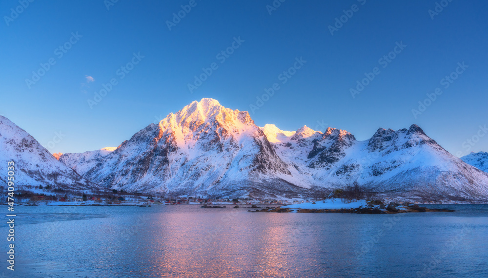 日落时分，美丽的雪山和湛蓝的天空倒映在水中。冬天的风景与雪