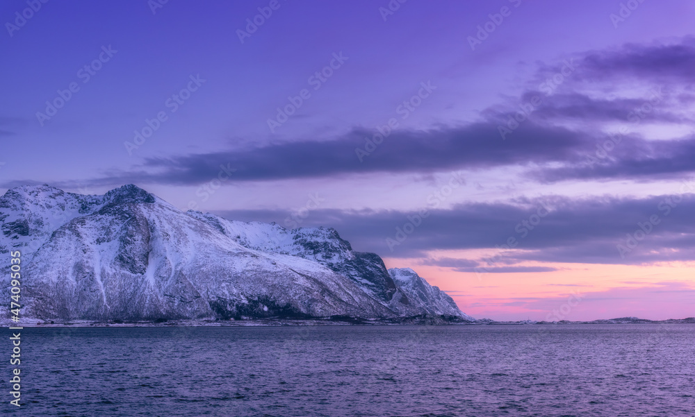 美丽的雪山和黄昏时映在水中的紫罗兰色天空。带着se的冬季景观