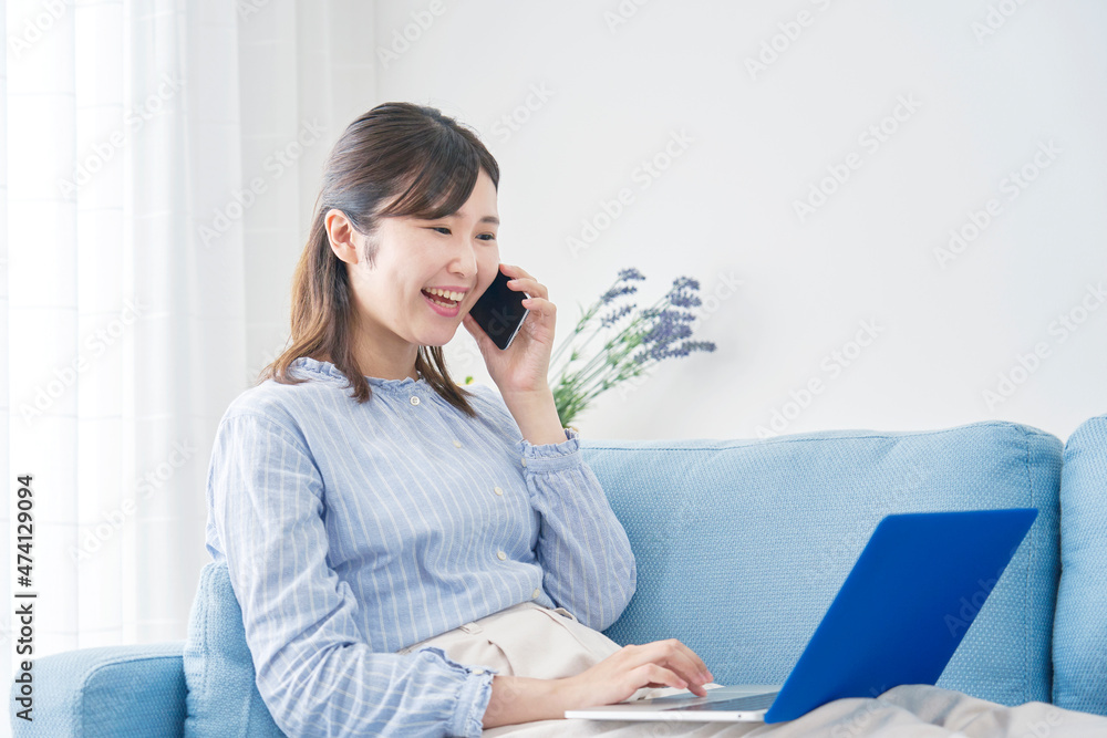 女性　電話する　パソコン　リビング