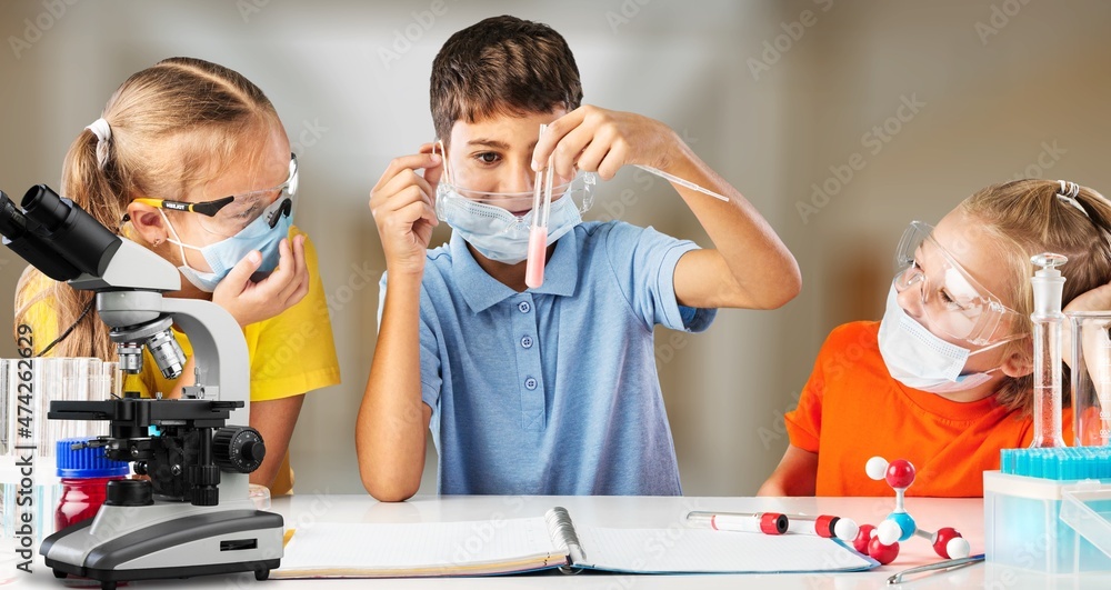 快乐的小学生在学校实验室的生物化学课上工作