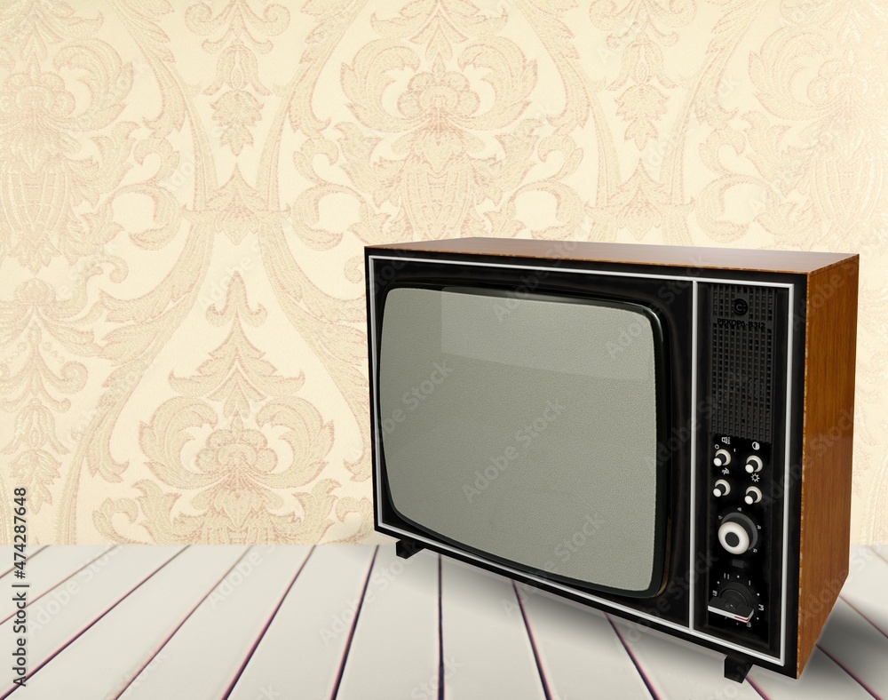 一台20世纪70年代的老式电视机放在一张木制桌子上