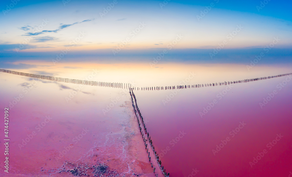 黎明天空背景下的粉红色湖水。无人机视图。