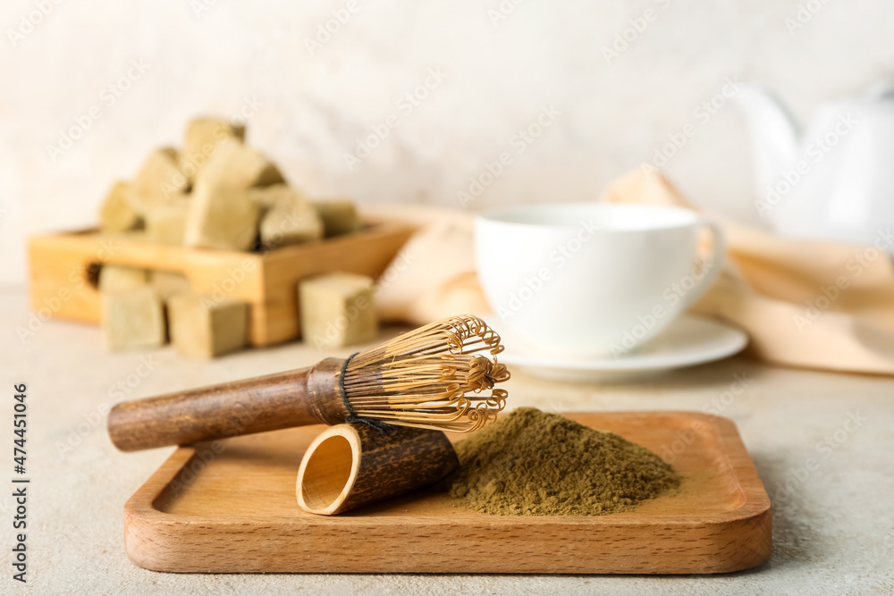 Wooden board with hojicha powder and bamboo chasen on light background