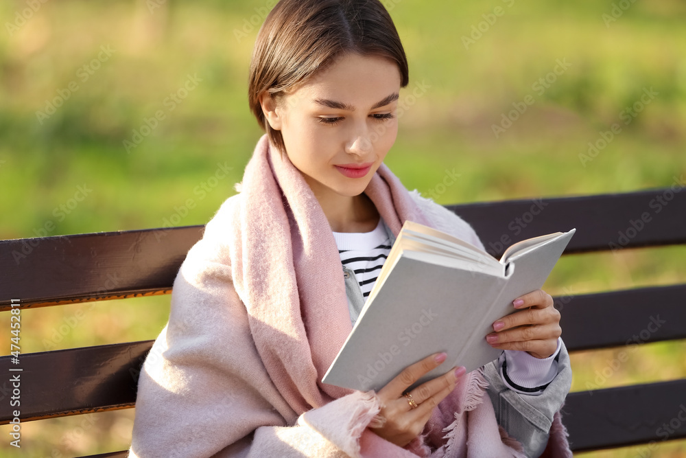 秋天公园木长椅上有格子看书的美女