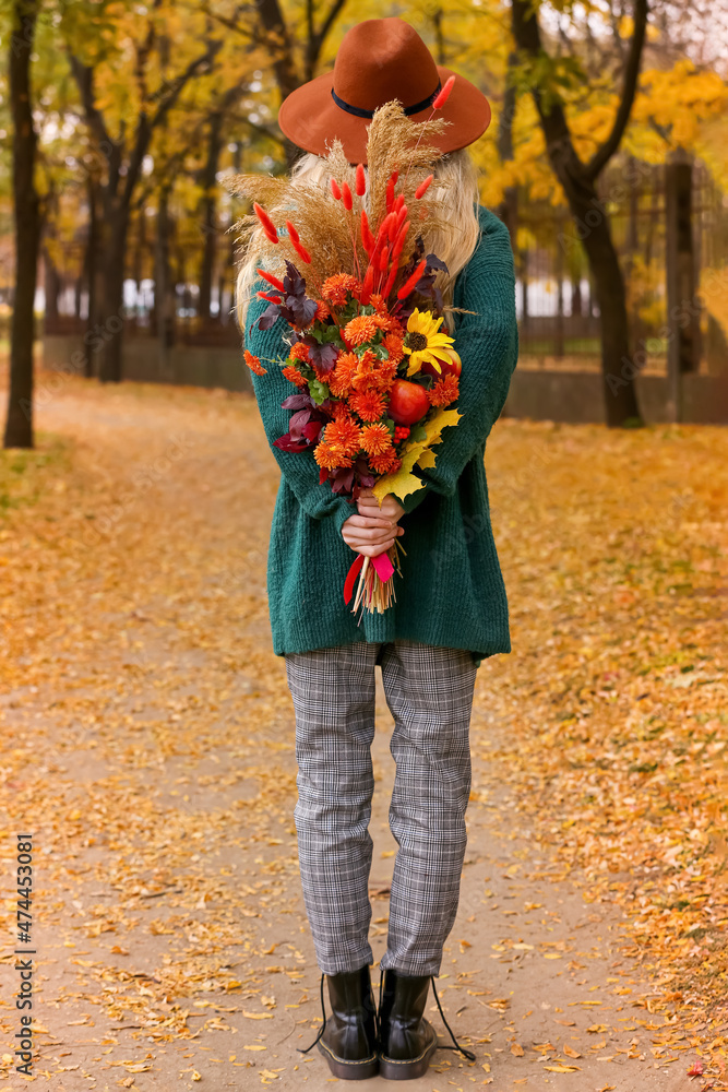 秋天公园里背着花束的年轻女子