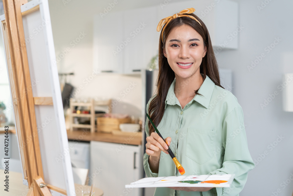 亚洲年轻艺术家女孩在家画板上涂色的肖像