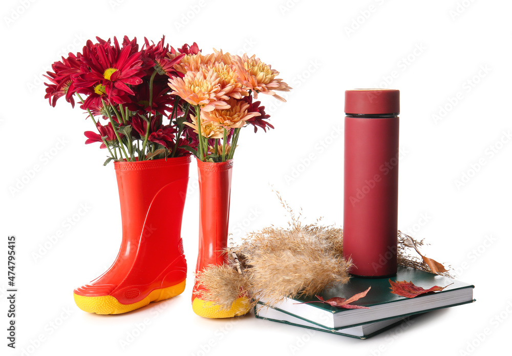 白底带花、保温瓶和书的橡胶靴