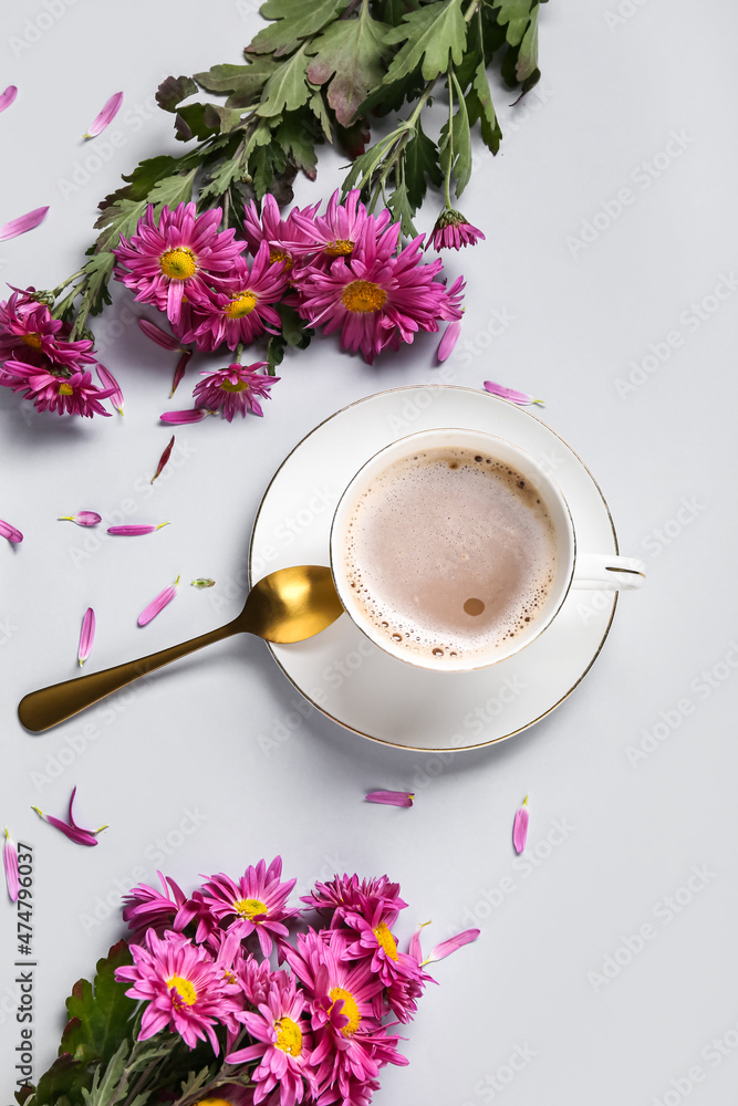 用一杯咖啡和白色背景上美丽的菊花组成