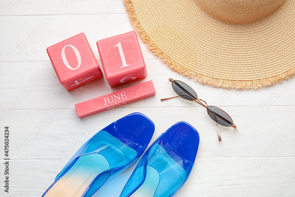 日期为6月1日的日历，浅色木质背景的鞋子、太阳镜和帽子