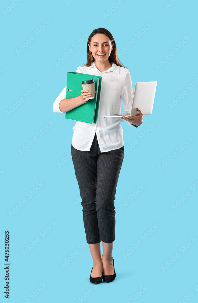 漂亮的年轻女人，彩色背景上有文件夹、咖啡和笔记本电脑