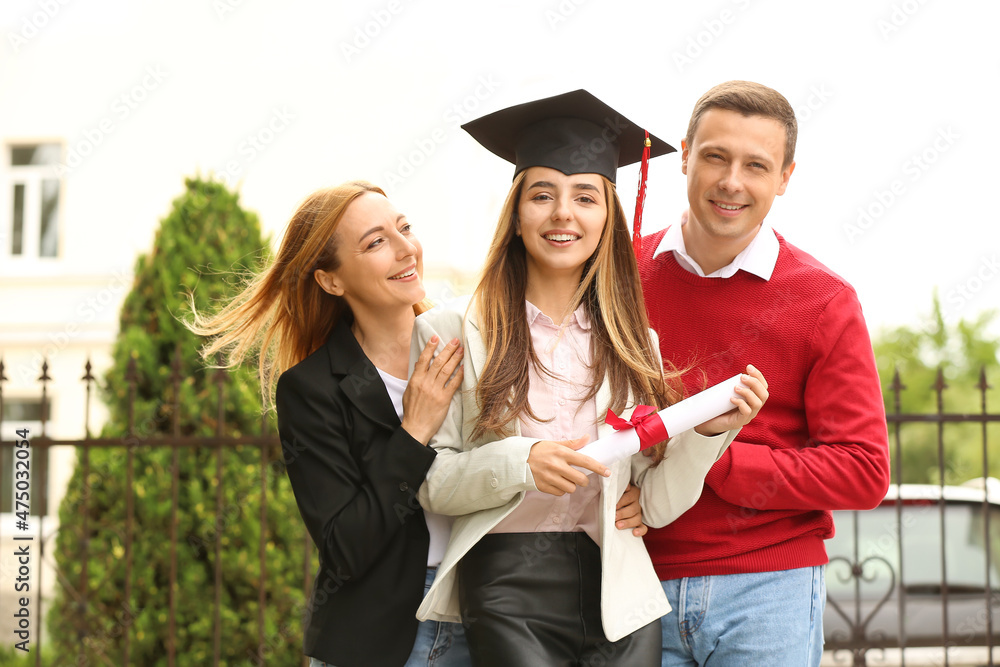 毕业日快乐的年轻女人和她的父母在一起