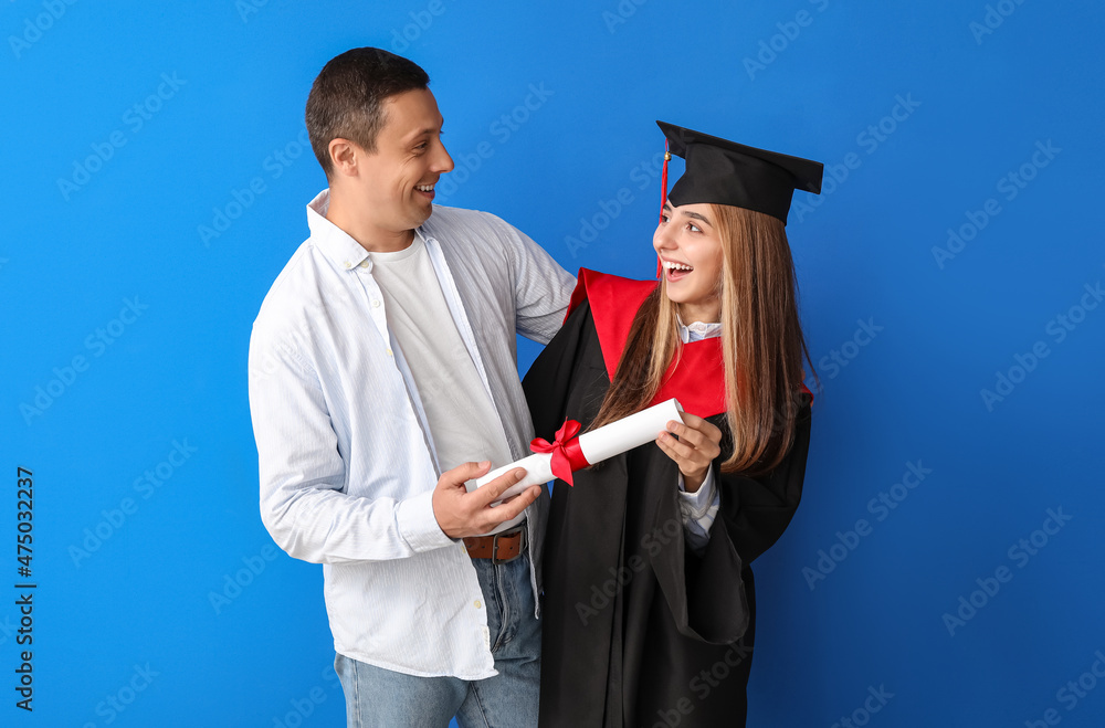 快乐的女毕业学生和她的父亲在彩色背景上