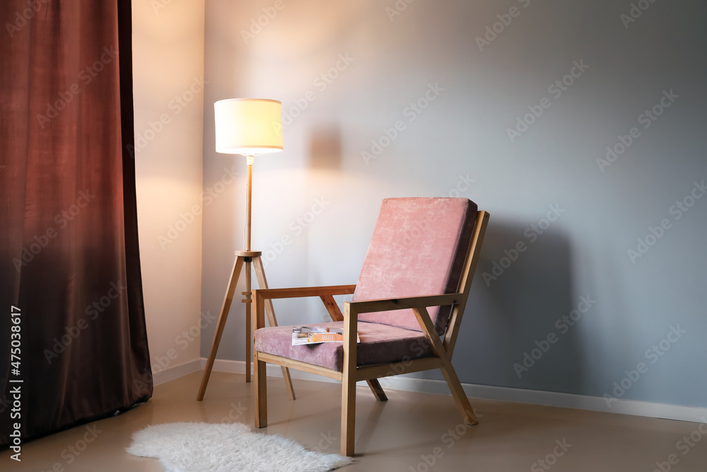现代室内，配有时尚的木制扶手椅和灯光墙附近的灯具