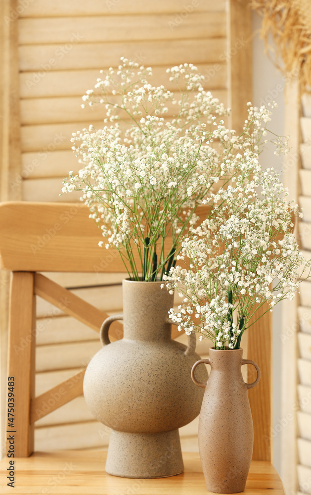 折叠屏风附近的木椅上放着吉普赛花的花瓶