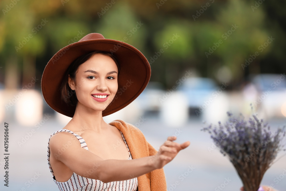 年轻快乐的女人在户外拿着一束美丽的花