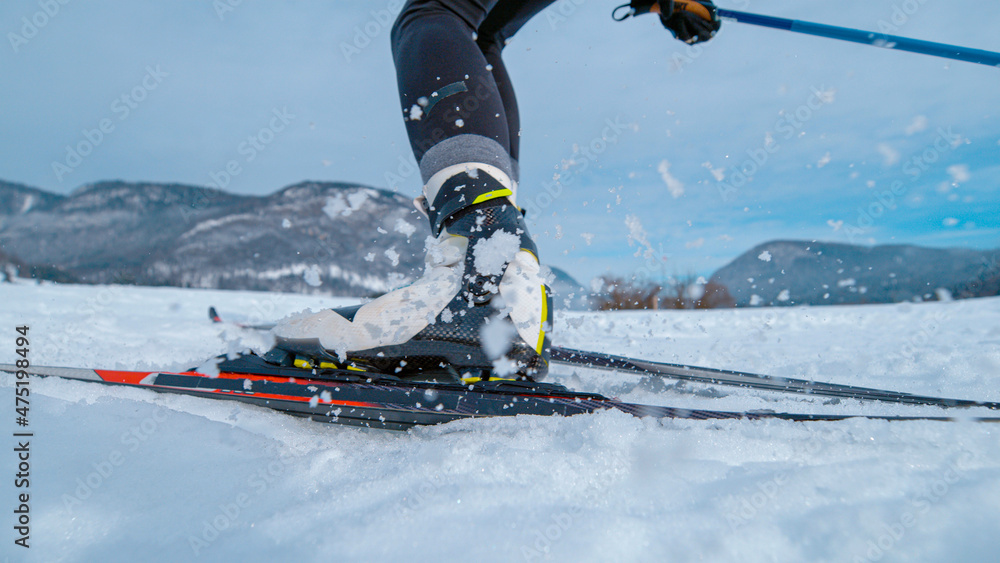 低角度：北欧职业滑雪运动员推下滑雪板和滑雪杆。