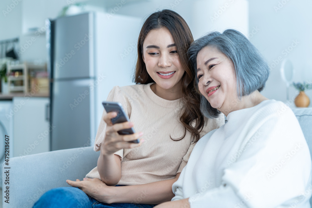 Asian lovely family, young daughter use phone selfie with older mother