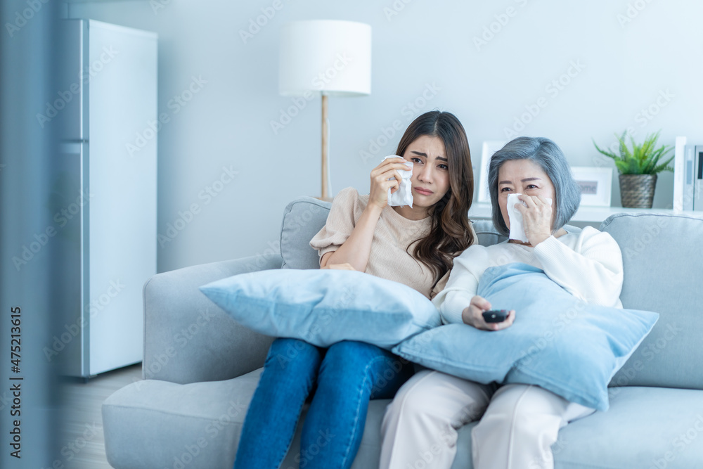 亚洲高级熟女和女儿坐在沙发上看悲伤电影