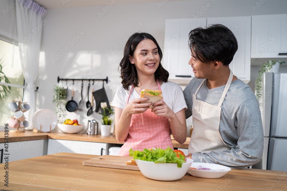 亚洲年轻新婚夫妇在家里的厨房里共度时光