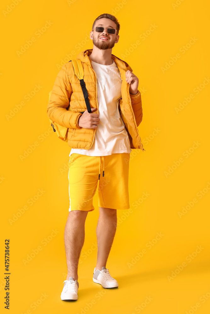 穿着黄色背景夹克的时尚年轻人