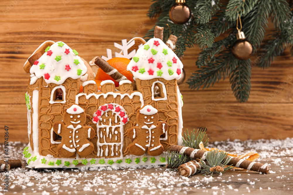 美丽的姜饼屋和木制背景的圣诞装饰
