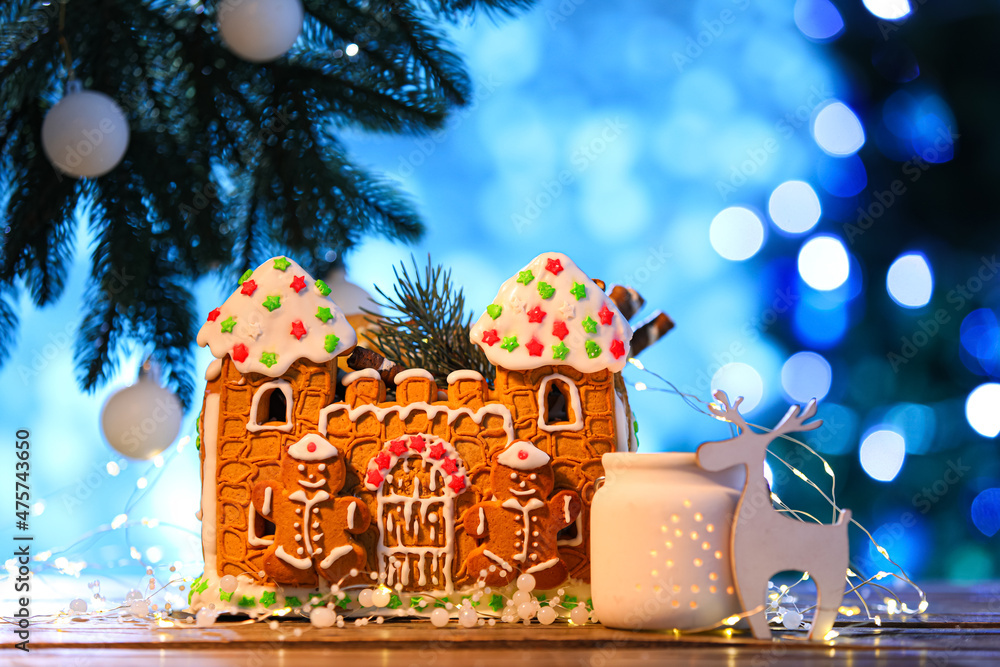 漂亮的姜饼屋和桌子上模糊背景的圣诞装饰
