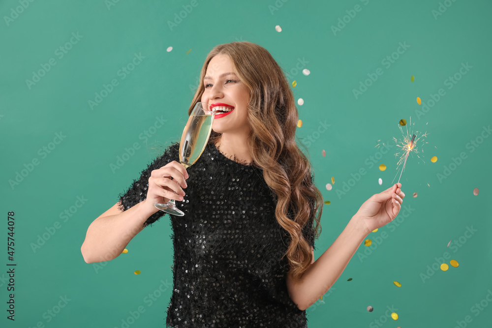 美丽的年轻女人，绿色背景下有圣诞亮片和香槟