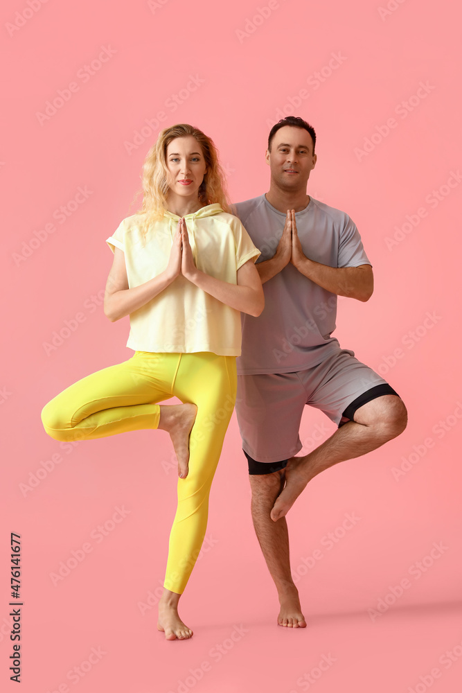 运动情侣在彩色背景下练习瑜伽