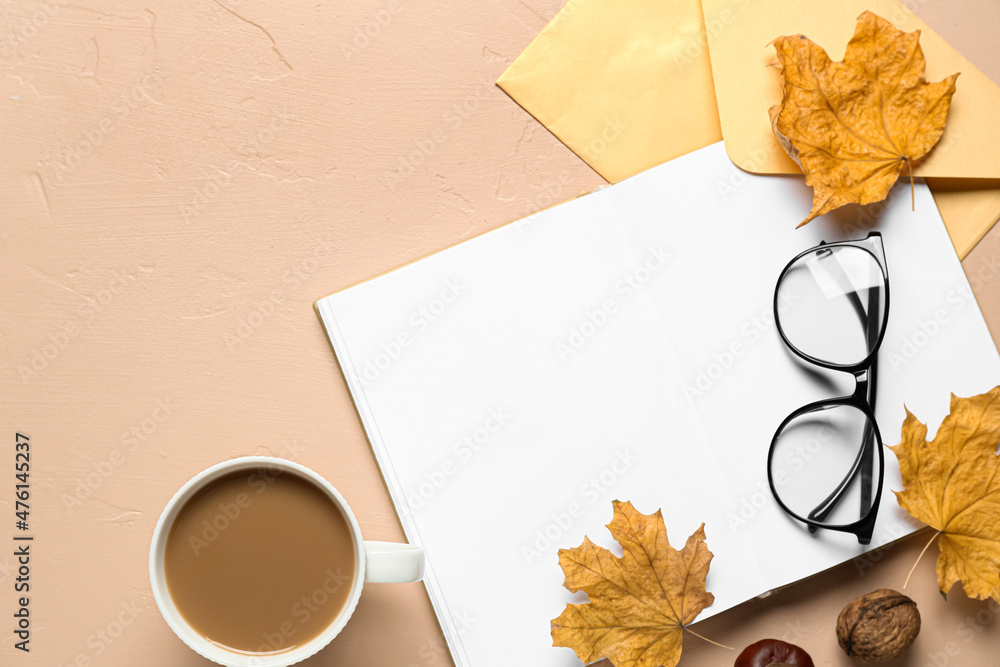一杯美味的咖啡，一本空白的书，米色背景的秋叶和眼镜