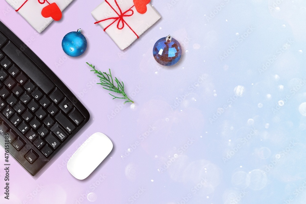 圣诞节和新年办公空间，配有键盘电脑、无线鼠标、小饰品和礼品盒。