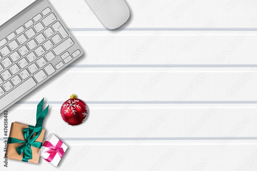 圣诞和新年办公空间，配有键盘电脑、无线鼠标、小玩意、礼品盒。