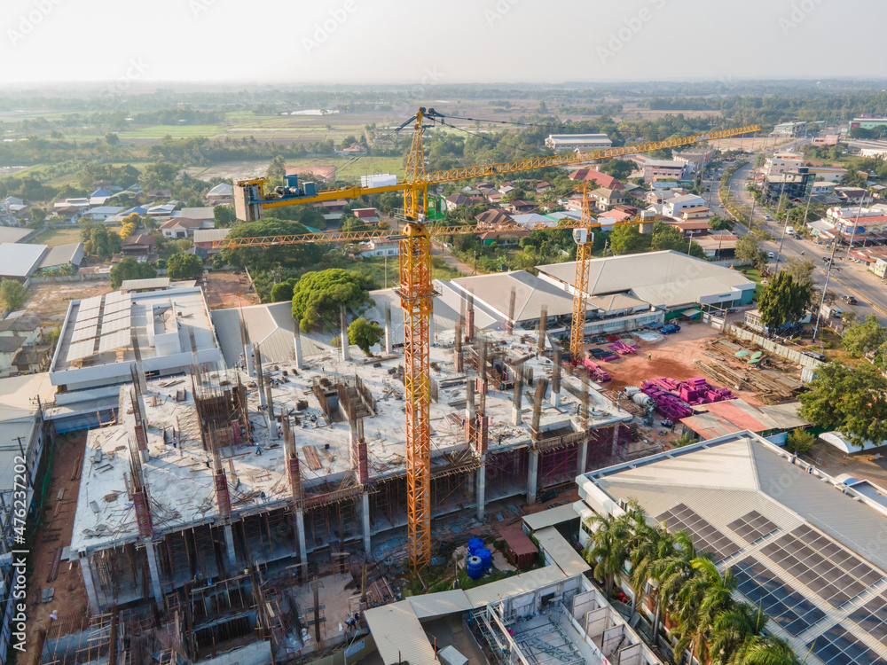 Aerial view of building crane on construction site and have communities and cities around.