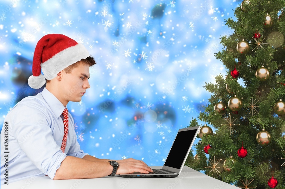 年轻快乐的男人独自在家庆祝圣诞节时通过笔记本电脑进行视频通话。