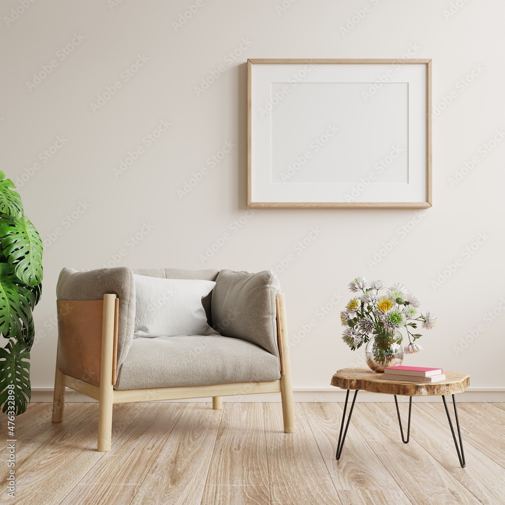 方形框架海报模型，白色墙壁背景上有扶手椅和绿色植物。