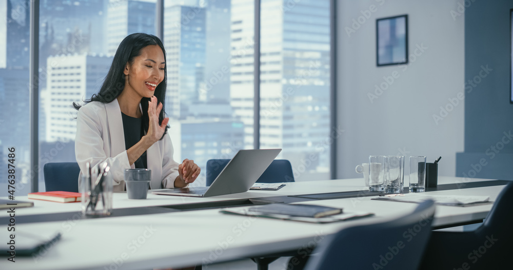 办公室视频电话会议：成功的亚洲女商人通过L与合作伙伴交谈的画像