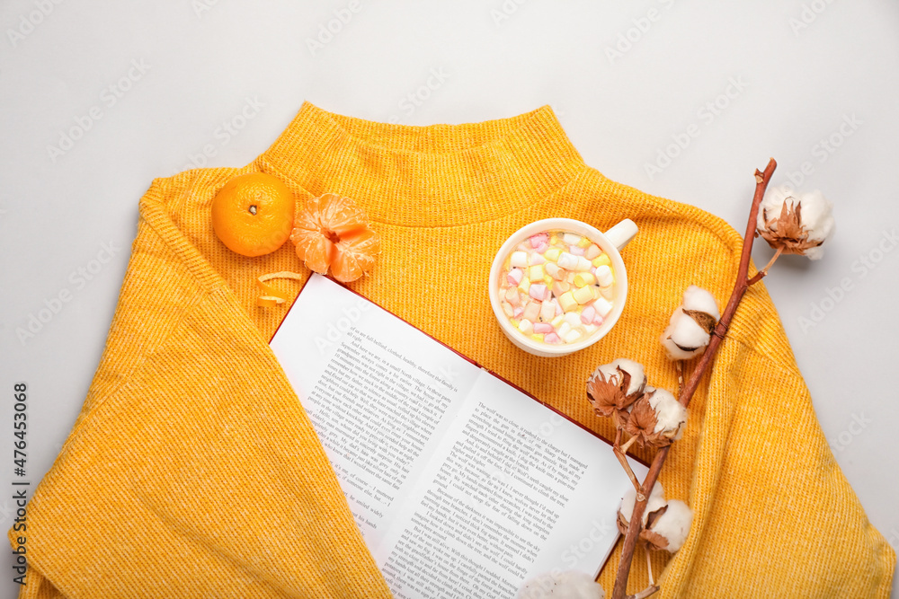白色背景下的书籍、毛衣、一杯可可和橘子的冬季作文