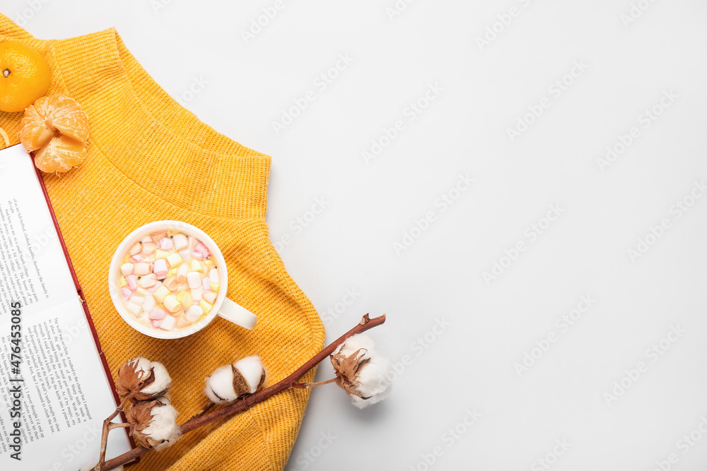 白色背景下的书籍、毛衣、一杯可可和橘子的冬季构图，特写